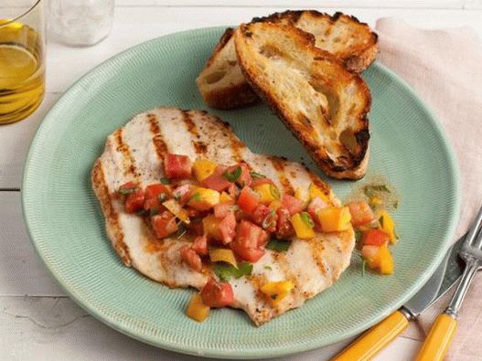 Photo d'escalopes de poulet grillé avec salade de tomates et de légumes verts
