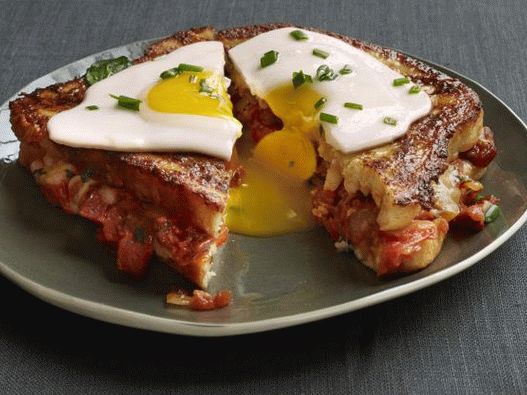 Toasts français avec de la confiture de tomates, du bacon et des œufs au plat