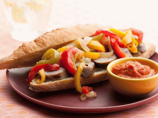 Photo Hot dogs avec saucisses grillées, poivrons, oignons et sauce au curry