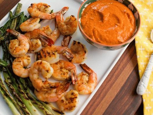 Crevettes frites sur des brochettes avec une sauce romesco