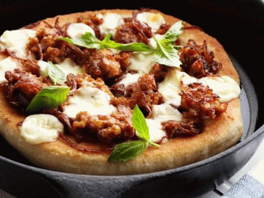 Photo Pizza avec de la viande hachée et de la confiture d'oignons dans une casserole