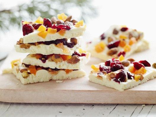 Photo Une tablette de chocolat blanc avec des pistaches entières, des canneberges séchées et des abricots secs