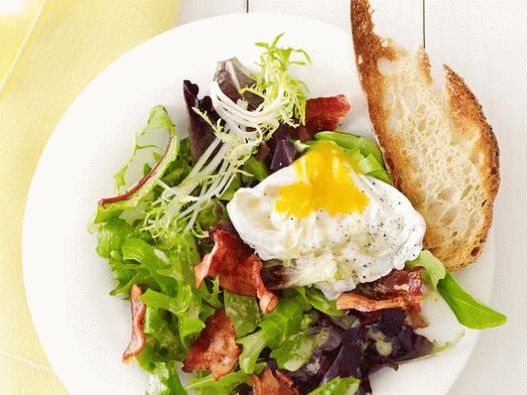 Salade de photo avec oeuf poché et bacon dans un café