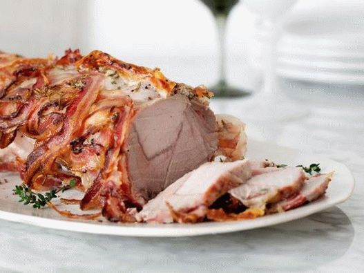 Photo de longe de porc enveloppée dans du bacon au four