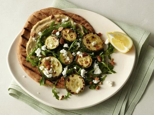 Tortilla aux courgettes cuites au four, houmous, roquette, fromage de chèvre et amandes